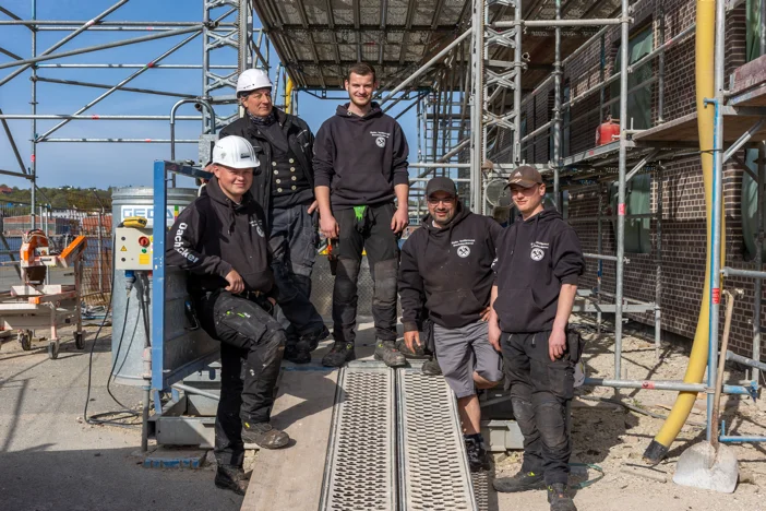 Dachdecker stehen vorm Baustellengerüst
