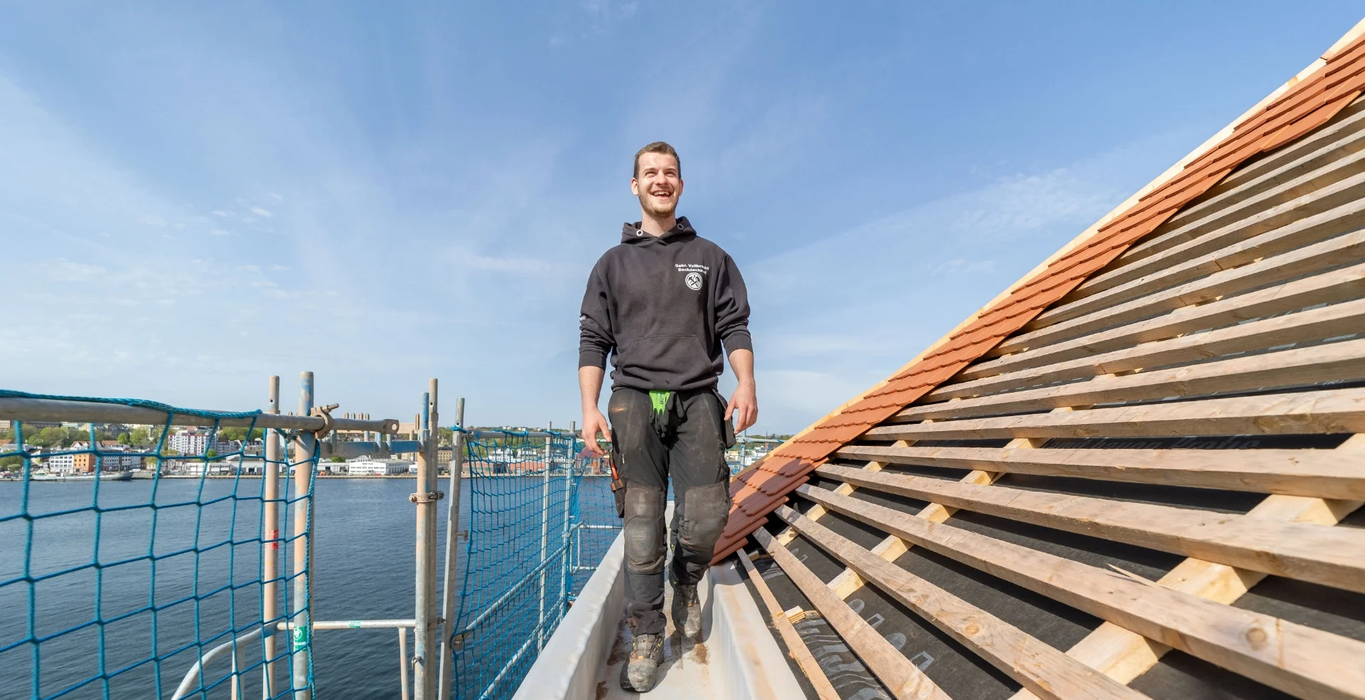 Ein Dachdecker an der Dachbaustelle vor der Förde