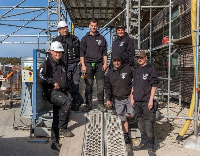 Dachdecker vom Team Vollbrecht vor einer Baustelle